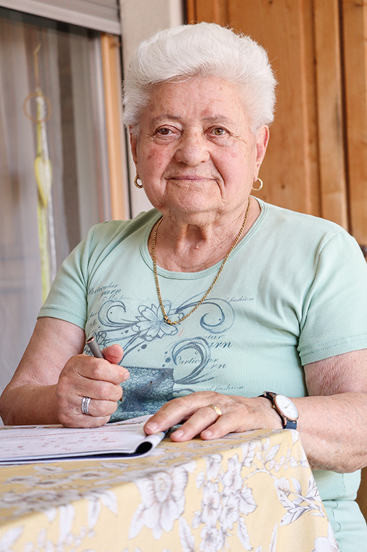 Theresia Riedl, Wwe Wegmann, genannt Tresl Jg.1934, Schluderns. Sie sitzt gerne auf der Terrasse ihrer Seniorenwohnung, liest Zeitungen, Zeitschriften, Romane und löst Rätsel. 