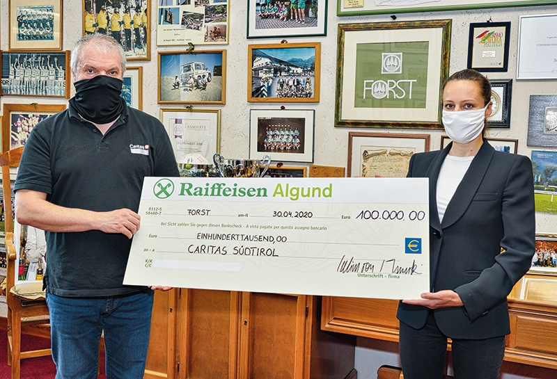 Cellina von Mannstein der Brauerei FORST übergibt den Scheck von 100.000 Euro an den Direktor der Caritas Südtirol Paolo Valente.