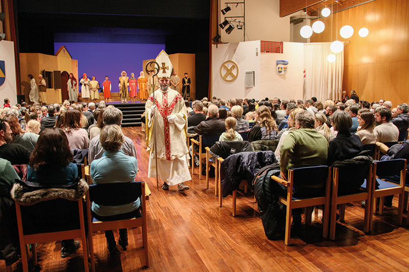Der Nikolaus, gespielt von Michael Ganthaler, verlässt die Bühne und verteilt  anschließend Nikolausbrote an die Besucher