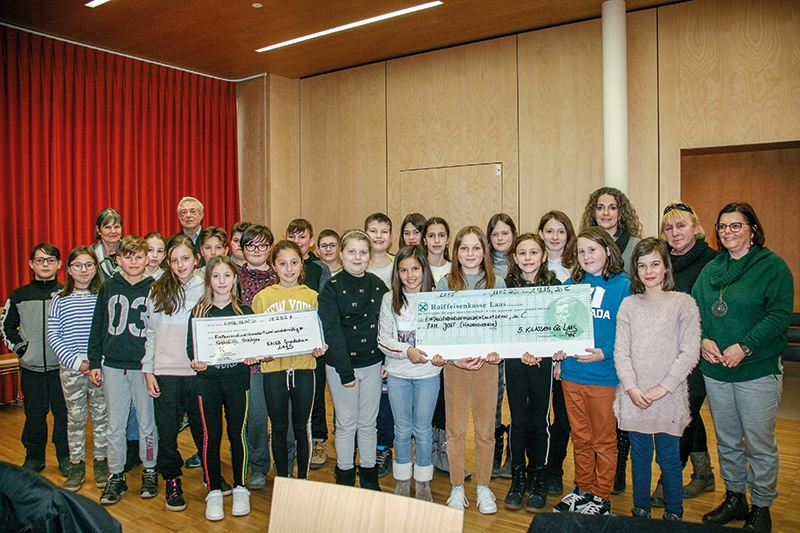Die Schülerinnen und Schüler der 5. A und der 5.B übergeben die Spenden in der Grundschule von Laas; im Hintergrund links: Helga Schönthaler Wielander und Josef Tschenett, hinten rechts: Petra Theiner, Maria Jostova (Oma der drei Halbwaisen) und Religionslehrerin Wally Gianordoli