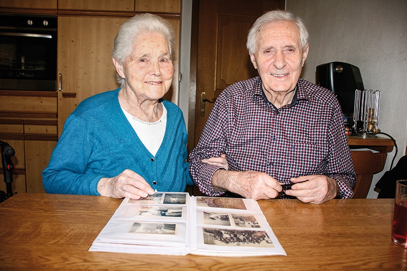 Das Ehepaar Maria Weiskopf, genannt Mariale, (geb. 1933) und Michl Hellrigl (geb. 1932)  in ihrer Wohnung in Tartsch. Beim Betrachten der Fotos werden Erinnerungen lebendig.