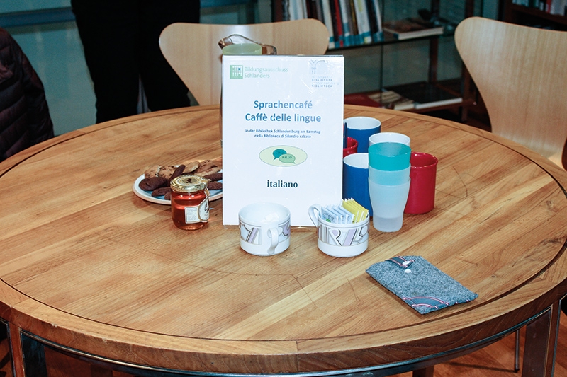 Beim Sprachencafé in der Bibliothek Schlandersburg wird auf einem Tisch ganz ungezwungen italienisch gesprochen und auf einem anderen deutsch. Und natürlich wird auch eine Kleinigkeit gegessen und getrunken.