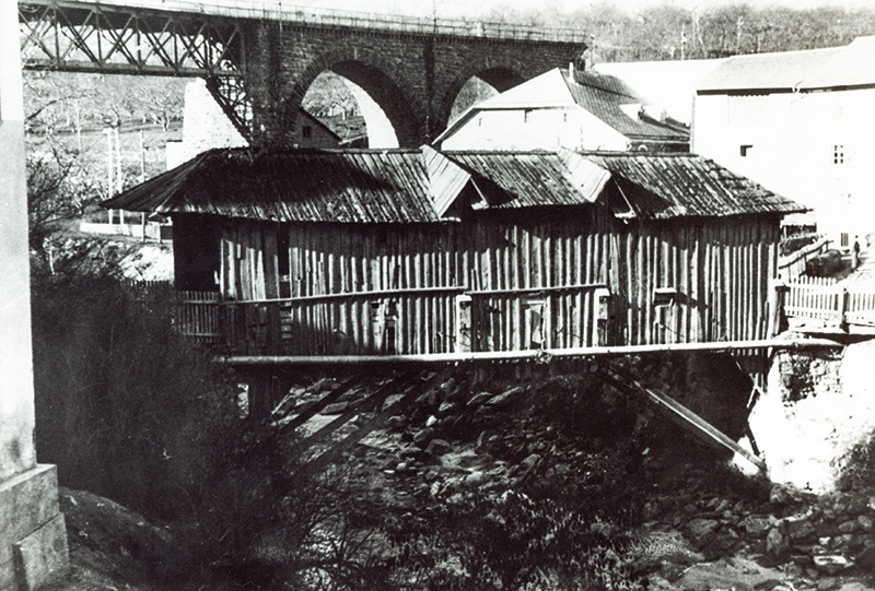 Die 1953 abgebrochene Göflaner Holzbrücke war überdacht und bekam Licht nur über die zwei Eingänge und über dreieckige Fensterluken im Dach. Aus dem Gemeindearchiv Schlanders: Abbruchkosten 1.250.000 Lire. Mit dem Bau der neuen Eisenbetonbrücke wurde der Ingenieur Hans Klotzner beauftragt; die neue Brücke konnte bereits am  25. November 1954 eingeweiht werden. Die etwa 100 Jahre alte Brücke war dem Schwerverkehr nicht mehr gewachsen; besonders die Nördersberger und die Arbeiten der Montecatini brauchten eine stärkere Brücke. 