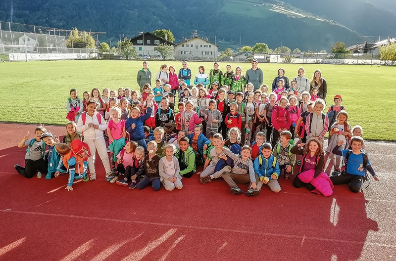 Schülerinnen, Schüler, Lehrpersonen und Betreuerteam vom ASC Laas auf dem Sportplatz
