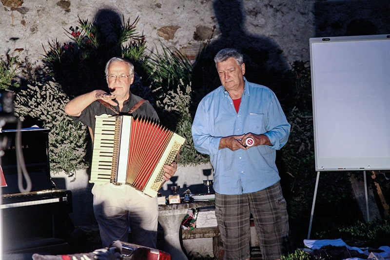 Karl Erlacher mit der Quetschkommode und „Randkünstler“ Matthias Schönweger im Garten des Gaudententurms in Partschins: Blickwinkelsprünge ohne Pausen