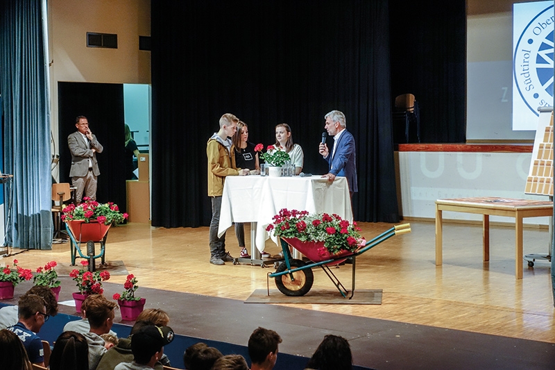 v.l: Marian Platzer, Sara Pitscheider, Ruth Gander mit Landesrat Arnold Schuler. Die Geranie, auch „brennende Liab“, ist immer noch ein Symbol für die Option