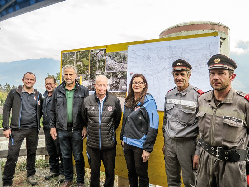 Vertreter des Landes, der Gemeinde und der Feuerwehr von Vetzan informierten über den Gefahrenzonenplan der Gemeinde Schlanders und erklärten den interessierten Schülern und Erwachsenen die Baumaßnahmen zum Hochwasserschutz am Vetzaner Bach. V.l.: Florian Nössing, Stefan Kobald, VizeBM Reinhard Schwalt, Roland Schweitzer, Teodora Niederjaufner, Michael Tappeiner und Gerd Stecher. 