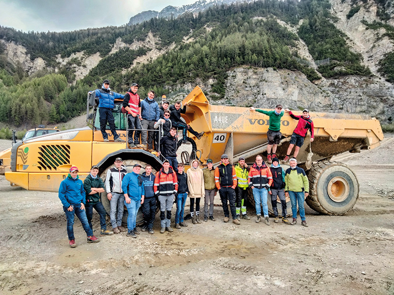 Den Lehrlingen der ersten Tiefbauerklasse samt Klassenlehrer Norbert Linser (rechts unten) wird von Klaus Patscheider (3. von rechts unten) und Armin Tempeler (4. von rechts unten) die Baustelle erklärt.