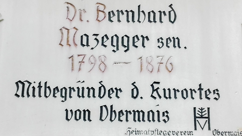 Zur Erinnerung an Dr. Bernhard Mazegger sen. ließ der Heimatpflegeverband Obermais an der einstigen Pension Mazegger (heute Pension Villa Maria) eine Marmortafel anbringen.