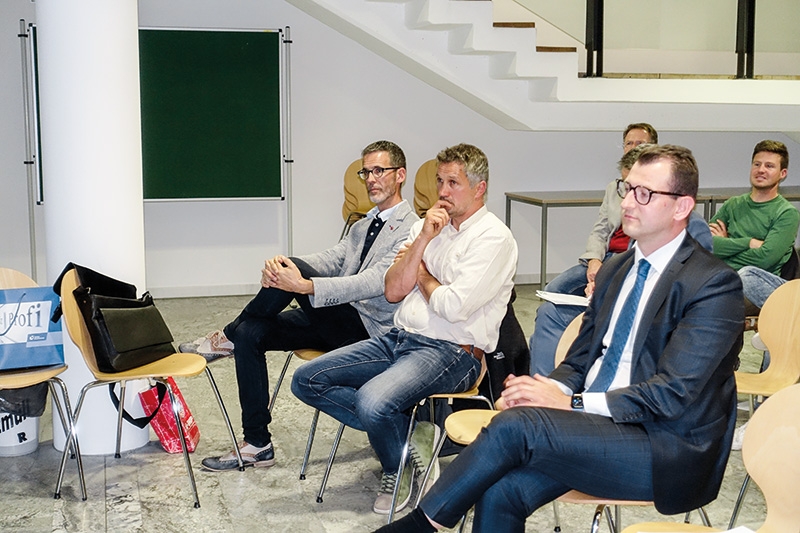 Die Referenten des Infoabends von links: Roland Furgler, Ethical Banking; Alexander Agethle, Hofkäserei Engelhorn; Andreas Platter, Union Investment. Sie folgen aufmerksam den Ausführungen von Direktor Markus W. Moriggl über das nachhaltige Wirtschaftsförderungspaket der Raika Obervinschgau.