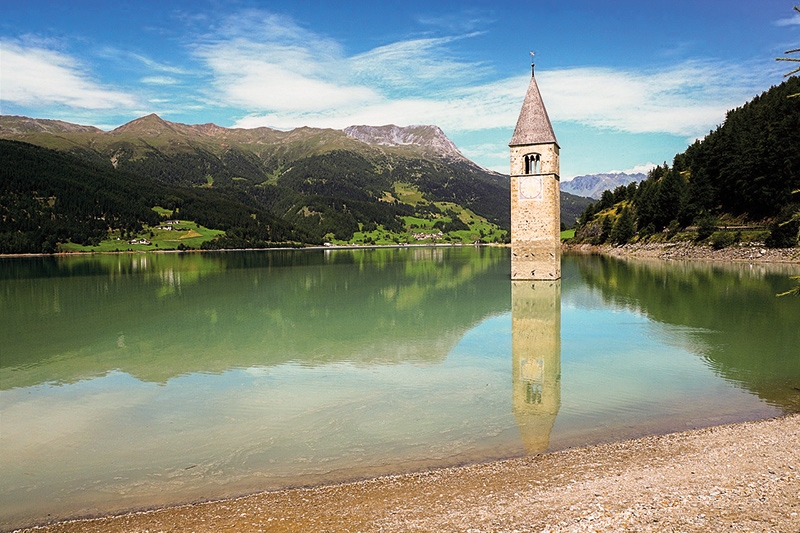 Strahlender Himmel über dem Reschensee der Gemeinde Graun im Vinschgau: Das Coronavirus lässt den Planeten aufatmen und reinigt ihn von schädlichen Abgasen.