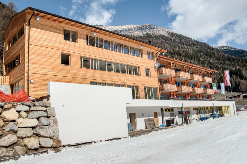 das Jugendhaus ist durch die zurückhaltende Architektur und durch die Holz-Fassadenverkleidung an den Bestand angepflegt.