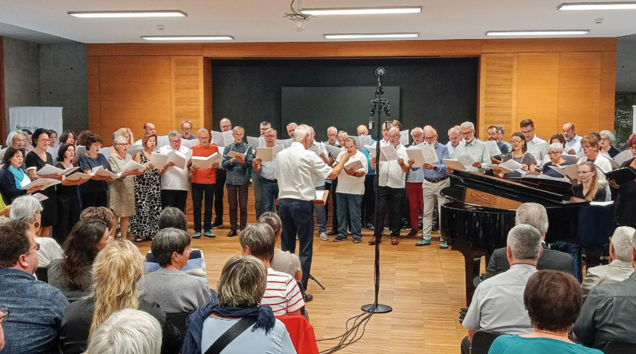 Roland Büchner dirigiert den Chor im voll besetzten Saal.