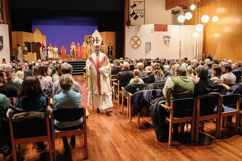 Der Nikolaus, gespielt von Michael Ganthaler, verlässt die Bühne und verteilt anschließend Nikolausbrote an die Besucher