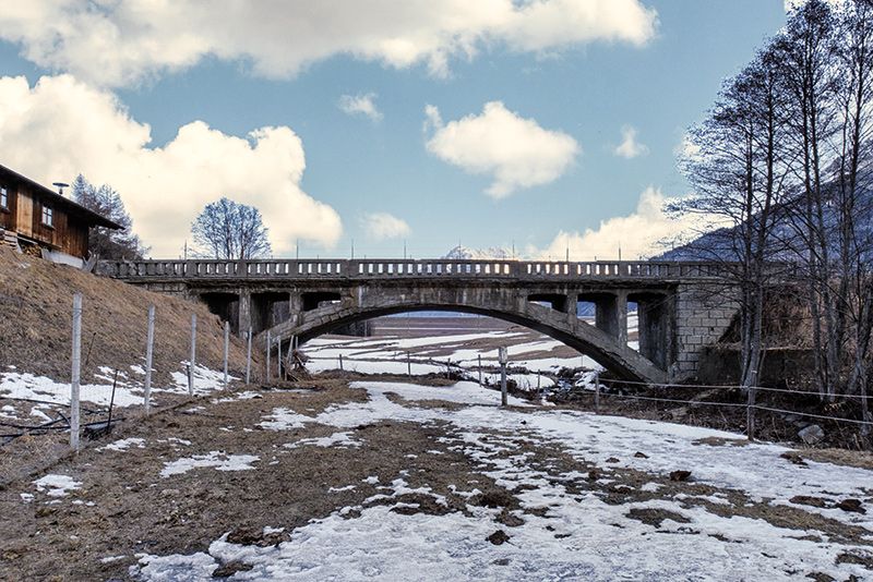 Die „Nui Brugg“ führt zur oberen und unteren Militärstrasse. Die Obere erschließt Außer-, Mitter- und Innerkaschon und führt über Schöneben nach Rojen. Über die Untere erreicht man Greinhof, Giern, die Kopferbrugg und Rojen aber auch Piz und Reschen. Letzere dient auch als Not- und Ausweichroute der Reschenpassstrasse.