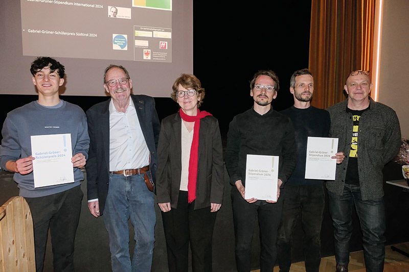 Preisverleihung im Kulturhaus von Mals. V. l.: Luis Parth, Uli Reinhardt, Ingrid Eißele, Hannes Jung, David Krenz, Peter Grüner. Grußworte sprachen Michael Pinggera vom Bildungsausschuss und Marion Januth, die Vizebürgermeisterin. Es moderierte Roman Drescher und für die musikalische Umrahmung sorgte das Trio „Schean dahin“ mit Fabian Alber, Lea Niederfriniger und Kathrin Kofler.