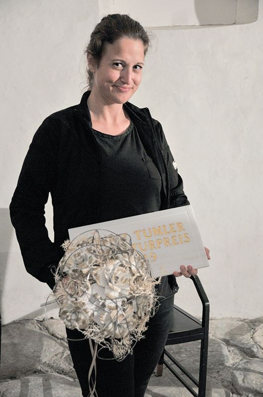 2019 freute sich Angela Lehner über das Preisgeld, zur Verfügung gestellt von der Südtiroler Landesregierung. Auf diesem Bild strahlt sie auch über die Siegertafel (Lasa Marmo u. Josef Mayr) und den Blumengruß der Laaser Kaufleute