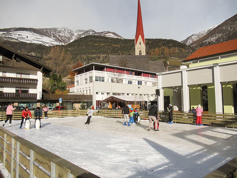  Jung und Alt vergnügt sich beim Eislaufen auf dem Kulturhausplatz in Schlanders.