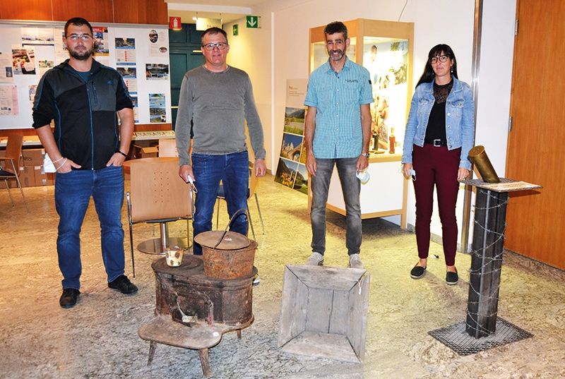 Die Filmemacher:innen bilden den Ausschuss des Ortlerfront Sammlervereins: v. l. Benjamin Tragust (Konzept, Text), Eberhard Reinstadler (Kamera, Schnitt), Gerald Holzer (Vizepräsident, Moderation), Historikerin Melanie Platzer (Text). Im Vordergrund: Ofen und Holzbehälter, originale Fundstücke von der Trafoier Eiswandstellung.