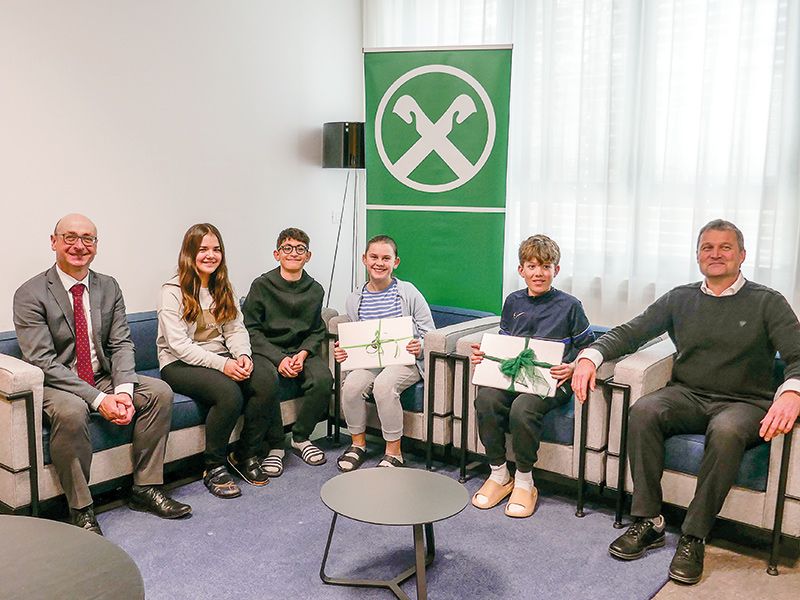 Raiffeisen-Direktor Dr. Michael Grasser und Schuldirektor Lukas Trafojer mit Laura, Renwar, Laura und Lukas bei der Übergabe der Notebooks