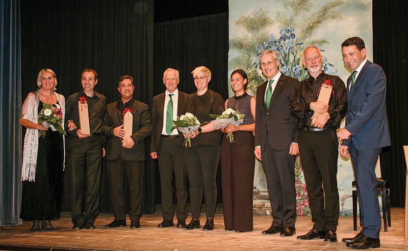 Blumen und Wein als Dankschön für Musiker:innen und Moderatorin aus den Händen der Raika-Vertreter