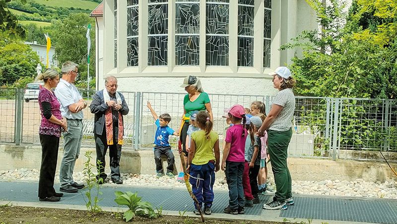 Pfarrer Florian Öttl segnet die neu angelegte Blumenwiese, die Kinder und die Erwachsenen