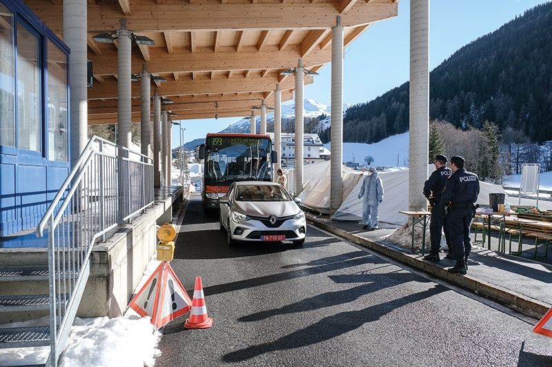 Ein Sanitäter des Österreichischen Roten Kreuzes hat soeben dem SAD-Schauffeur  das Fieber gemessen. Der Bus ist leer. Eine Ärztin steht in Schutzkleidung für den Ernstfall bereit. Für weitere Untersuchungen stehen zwei Sanitätszelte zur Verfügung. Zwei Polizisten kontrollieren die Einreise- bzw. die Durchreisegenehmigungen.