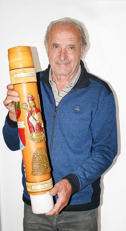 Hermann Steck, Jahrgang 1945, Mals, mit der Imkerkerze des Bezirkes Obervinschgau. Diese ist mit Abbildungen des Hl. Ambrosius und der Ortswappen geschmückt.