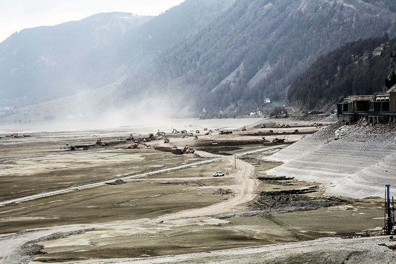 Zahlreiche Bagger, Tumperer und Laster schaufeln, führen und kippen Sand aus dem Reschensee