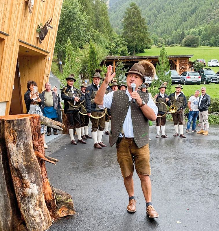 der Tauferer Revierleiter Dietrich Spiess mit den Musikanten:innen der „Jagdhornbläser Hirschruf“ im Hintergrund;
