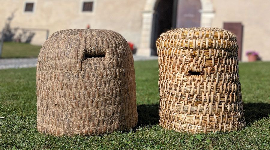 Ein älterer Bienenkorb (l.) und ein soeben entstandener (r.), der noch mit Kuhdung eingestrichen wird. Isoliert und hält die Mäuse fern!