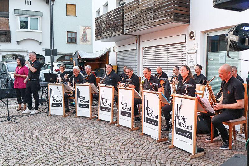 Die Malser Big Band mit Sängerin und Sänger auf dem Kirchplatz in Schluderns
