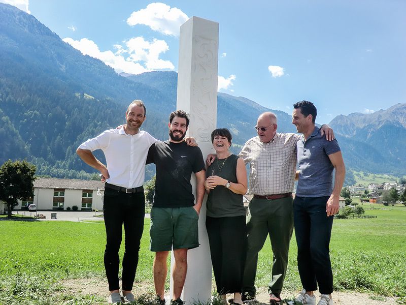 v. l.: Kurt Ratschiller, Produkt- und Marketingmanager der LASA Marmo GmbH; Elias Wallnöfer, Bildhauer; Claudia Schmauder, Szenografie Schmauder, Zürich; Walter Anderau, Präsident Stiftung Pro Kloster St. Johann Müstair, Ulrich Veith, Geschäftsführer Stiftung Pro Kloster St. Johann Müstair und dem gegenüberliegenden Hotel Chasa Chalavaina.